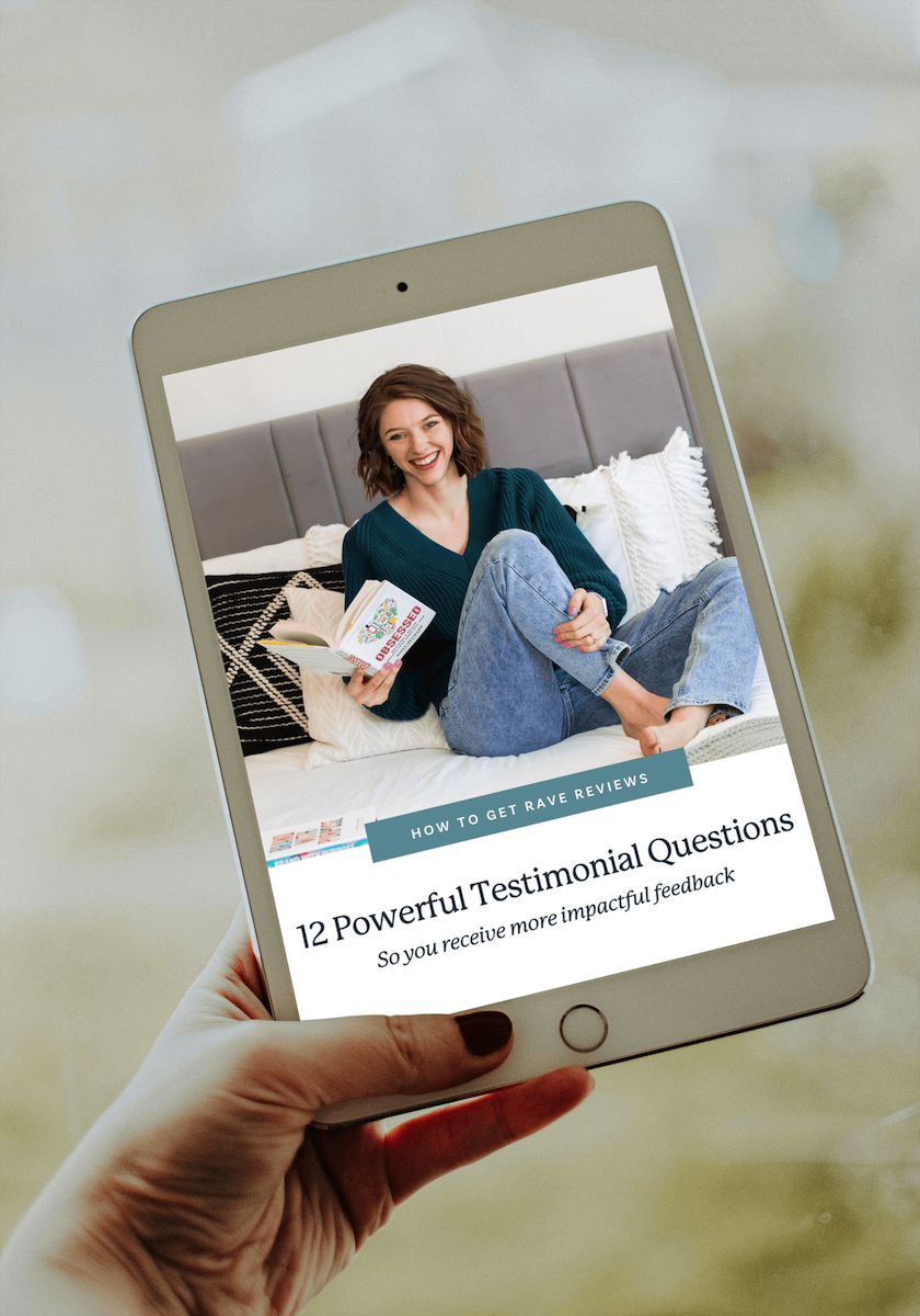 a woman holding a tablet that shows a freebie called "12 Powerful Testimonial Questions"